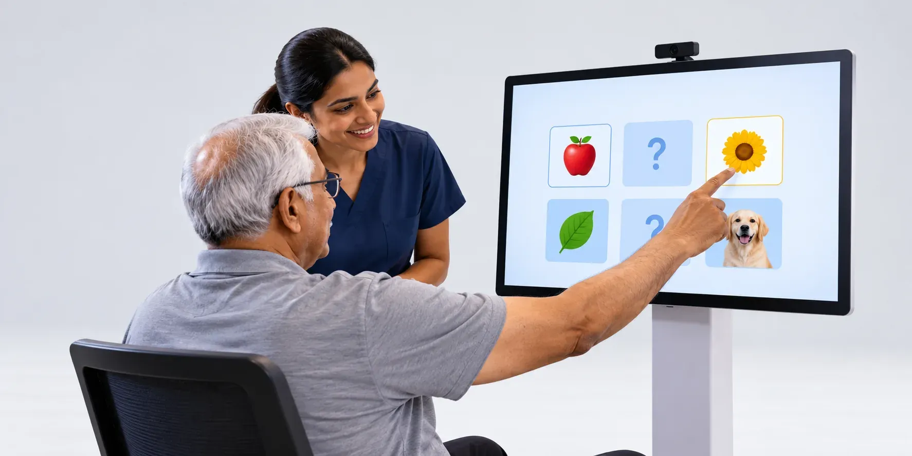A senior patient tapping a memory game on the Rewin Cognex touch screen while his therapist encourages him